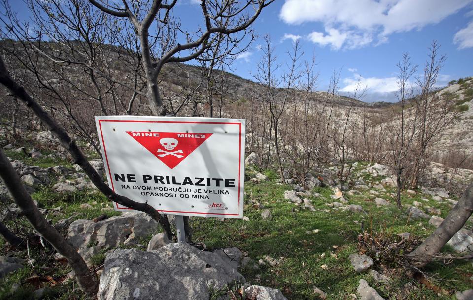  Just a stone's throw away from Modric's abandoned home, a sign warns of the dangers of landmines nearby