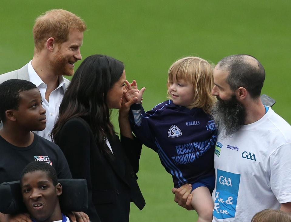  Meghan grinned as she took hold of the confident tot's hand as he reached for her head once more