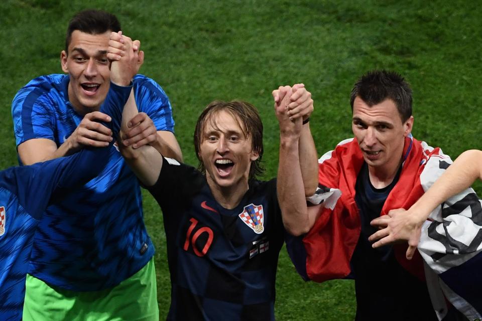  Luka Modric and Mario Mandzukic, right, enjoy themselves on the pitch following the extra-time win