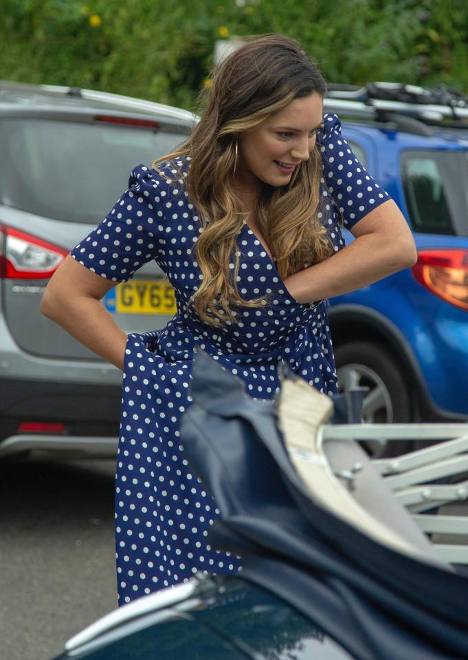  Kelly Brook readjusts her mic after suffering technical difficulties as she filmed the Antiques Roadshow