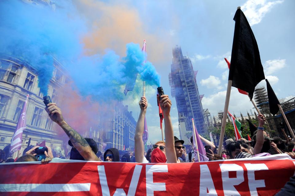  Anti-fascist campaigners wave flares and coloured smoke bombs in the air outside Parliament