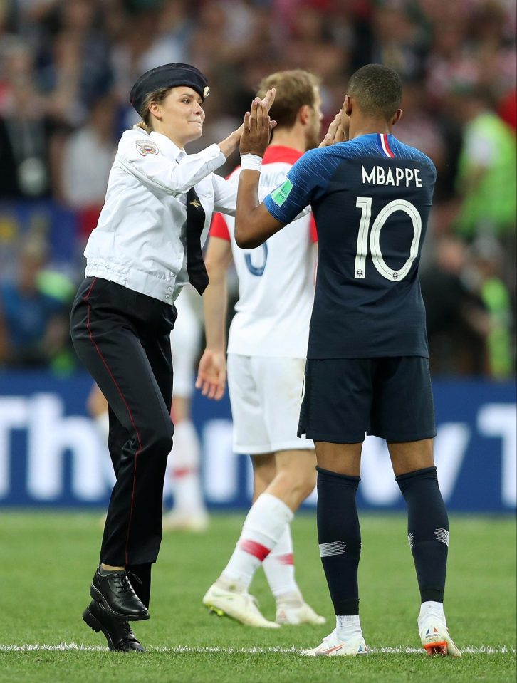  French star Kylian Mbappe gives a member of Pussy Riot a high five