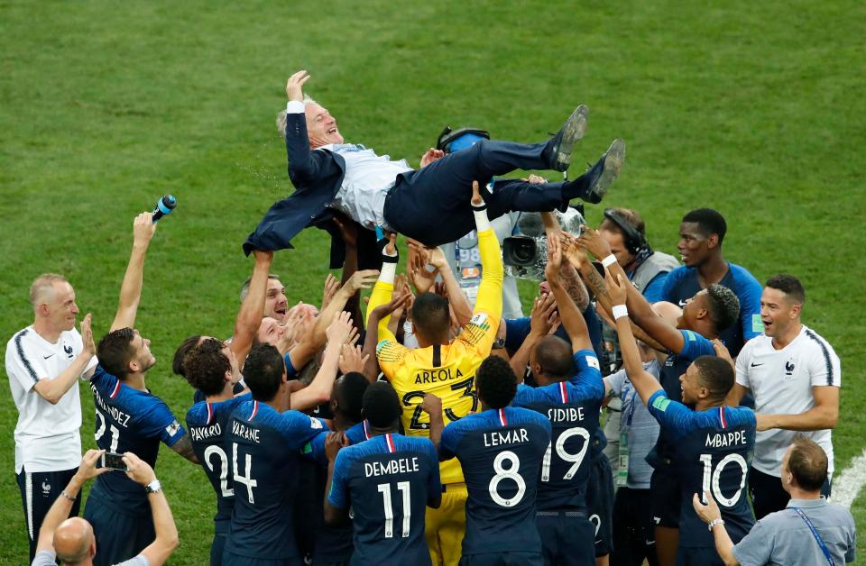  The French boss is hoisted into the air by his players after guiding France to World Cup final victory against Croatia