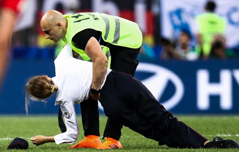  A member of Pussy Riot is dragged off the field of play by security