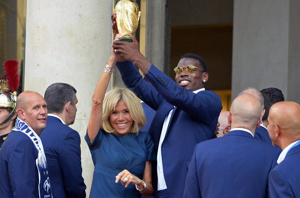  French First Lady Brigitte Macron holds the World Cup aloft with Paul Pogba