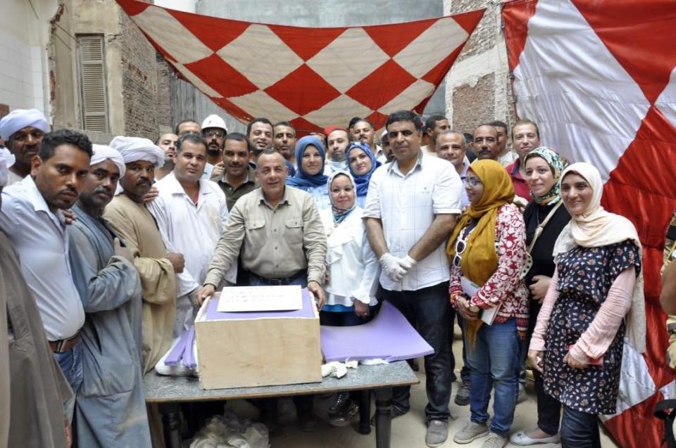  Archaeologists pose with a box containing the remains from the sarcophagus