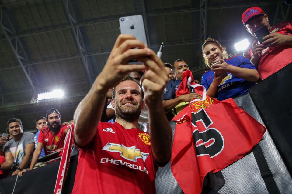  Juan Mata poses for selfies with fans after scoring the equaliser