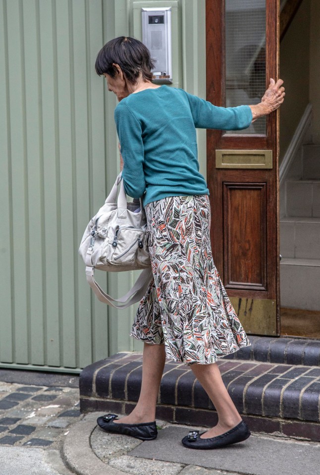 June wore a patterned skirt and a teal jumper