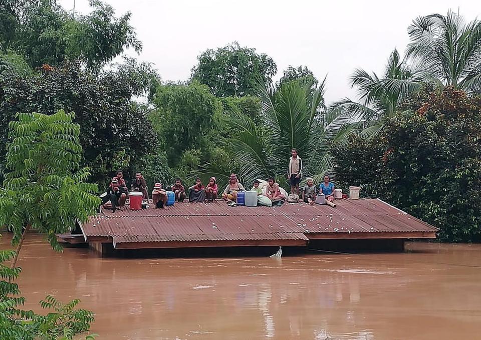  Heartbreaking images from the San Sai district of Attapeu province showed villagers on their roofs to avoid the water