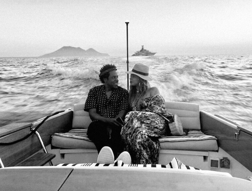  In one black and white snap, the couple gaze into each other's eyes on the back of a boat with their super yacht in the distance