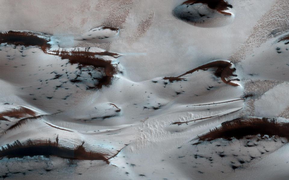  An image snapped by NASA's Mars Reconnaissance Orbiter shows the planet's northern-most sand dunes beginning to emerge from their winter cover of seasonal carbon dioxide (dry) ice