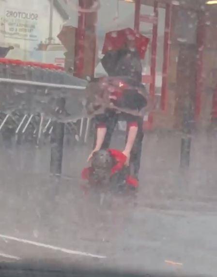  Luke Carlin brought his jacket outside to shelter the dog from the rain