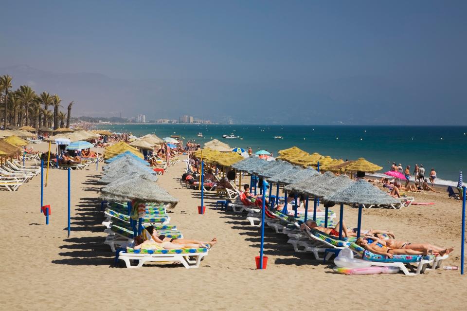  Sunbathers enjoying the beach in Torremolinos, Costa del Sol, Spain