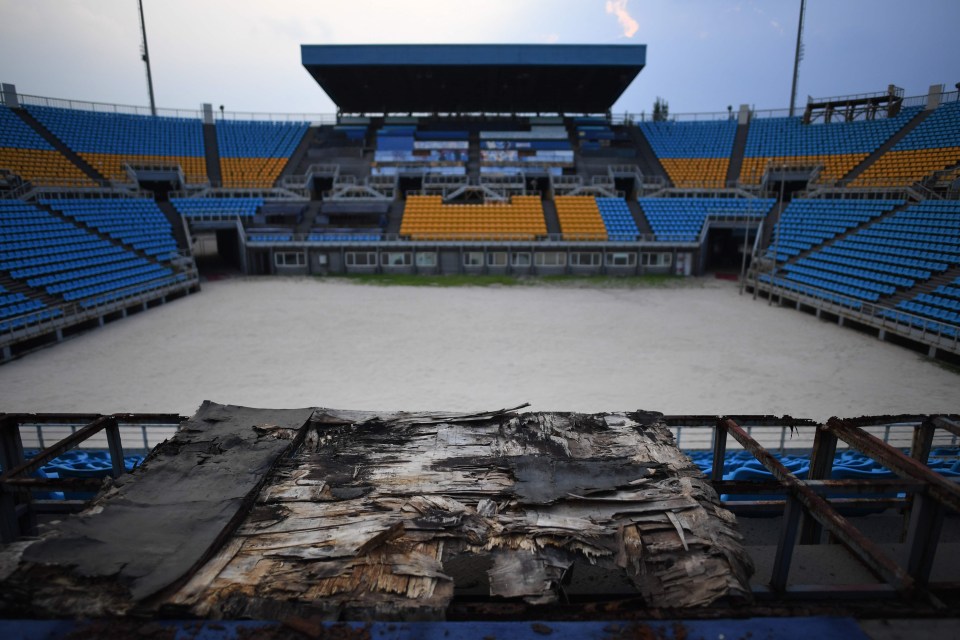 The beach volleyball stadium is little more than rusting metal, rotting wood and sand in the present day