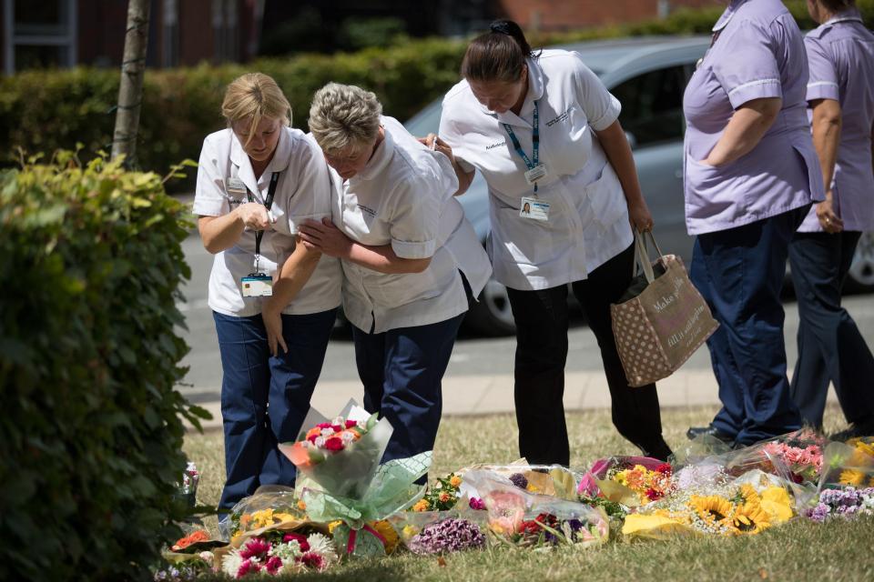  Colleagues of Samantha Eastwood gather round floral tributes at the University Hospital of North Staffordshire