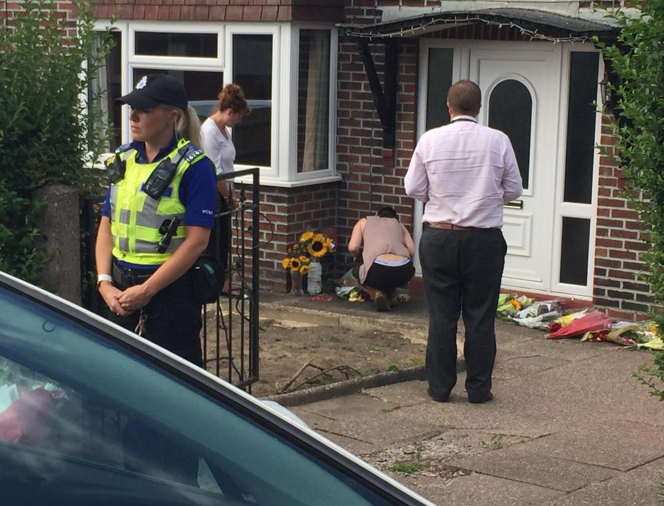  Gemma crouches to look at floral tributes and cards left at Samantha's home