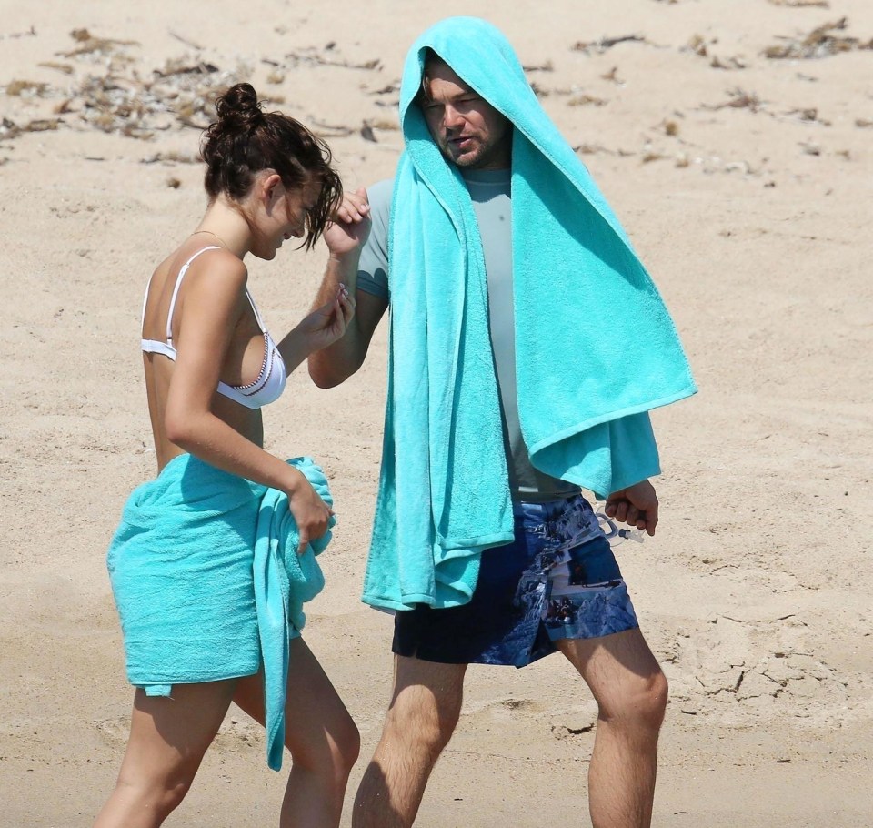 The couple giggled as they walked across the sand