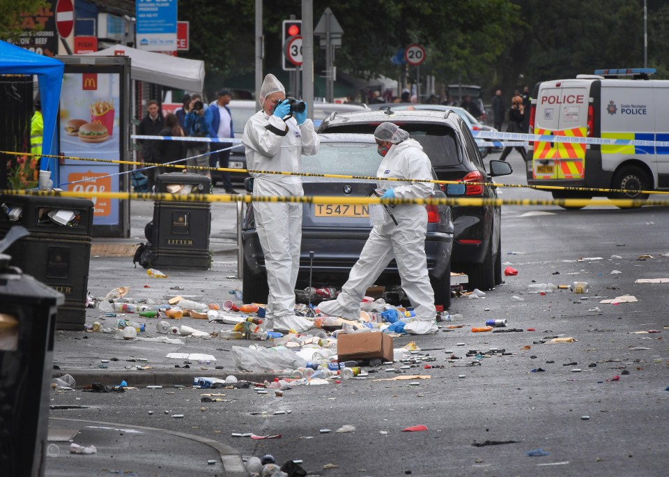 Forensic officers take photographs at the scene