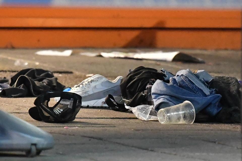  The crime scene outside a row of shops and restaurants was littered with clothes including a baseball cap and Nike trainers