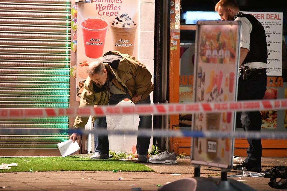  Officers gather clues after three people were injured in a shooting in North West London