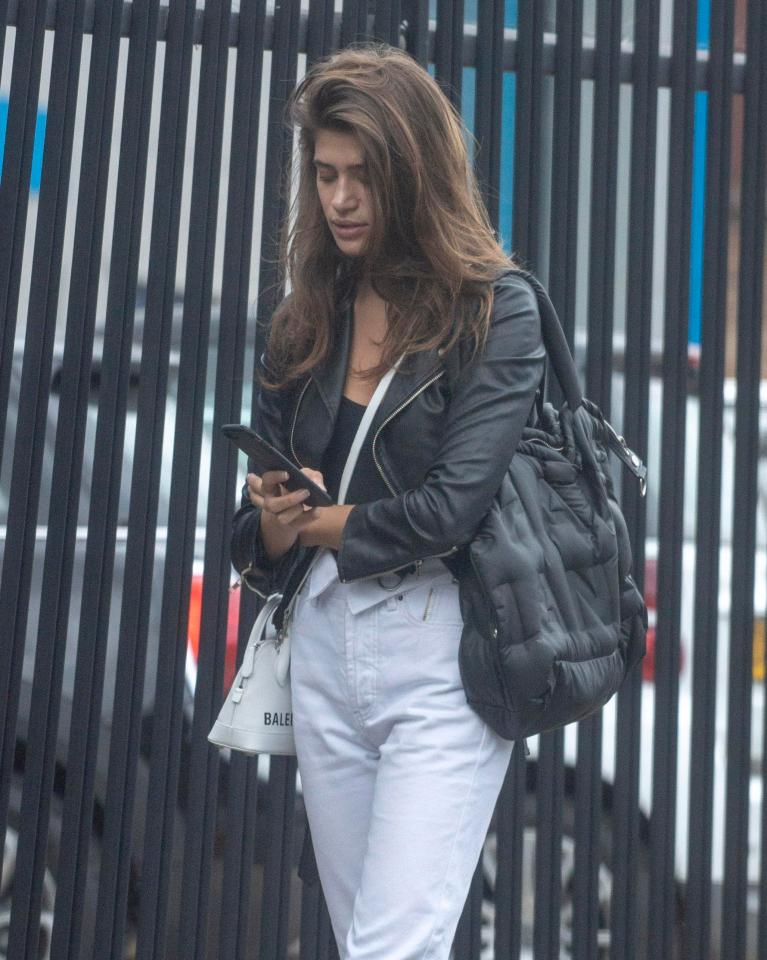  The model looked down at her phone as she walked along the street