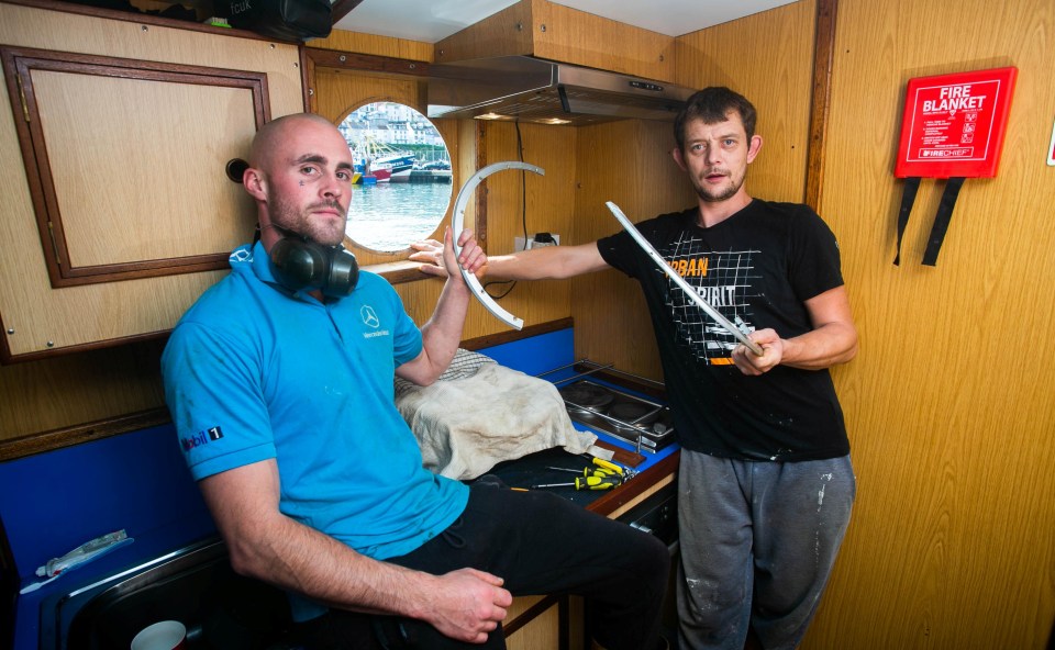 Fishermen Robert Morley and Kieran McKimmey next to a smashed window onboard of Golden Promise