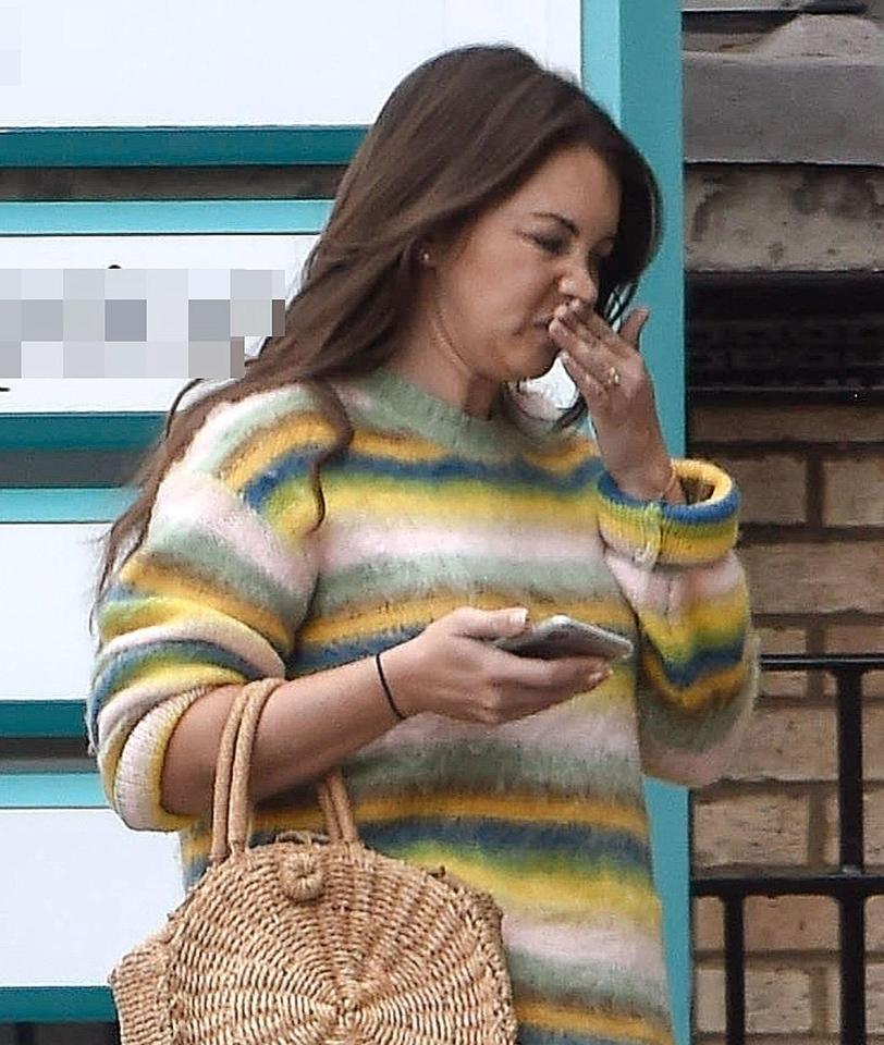  Lacey was seen pulling a face as she checked her phone