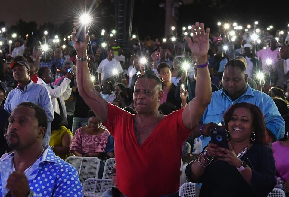  People hold up their lit mobile phones during 'A People's Tribute to the Queen' concert last night