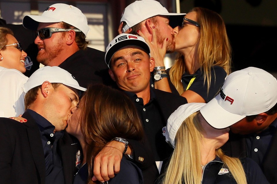 US ace Rickie Fowler looks on as J.B. Holmes, Erica Holmes, Jimmy Walker, Erin Walker, Jordan Spieth, Annie Verret, Justine Reed and Patrick Reed celebrate during the 2016 singles matches at Hazeltine