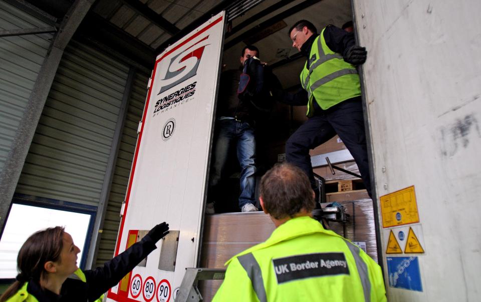  Stowaway passenger climbs down from a lorry after being discovered in a trailer at Calais