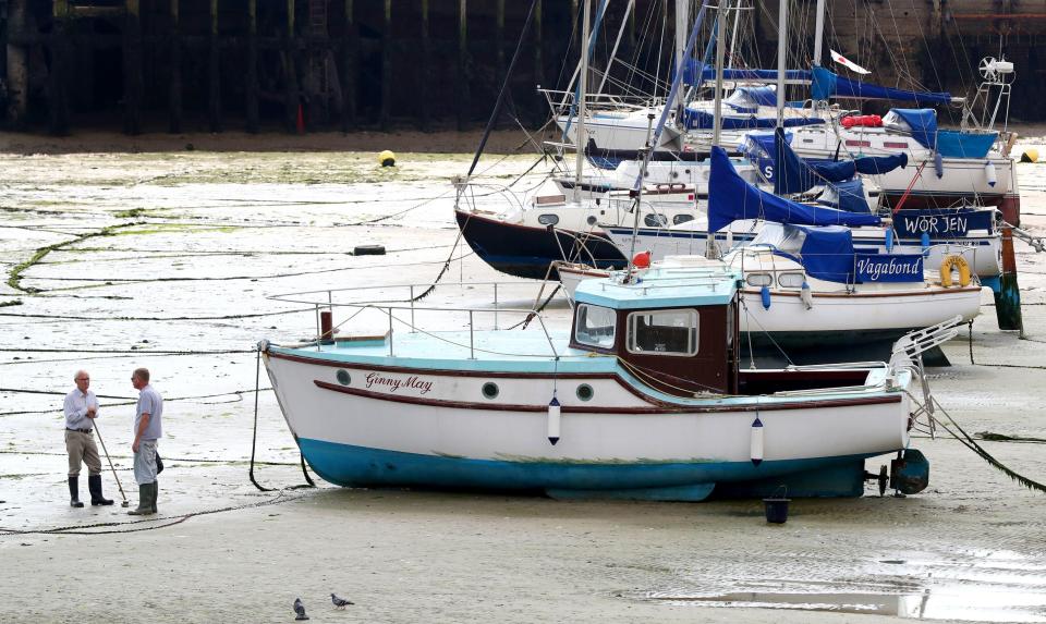  A man cleans his boat during the fine weather in Folkestone harbour, Kent