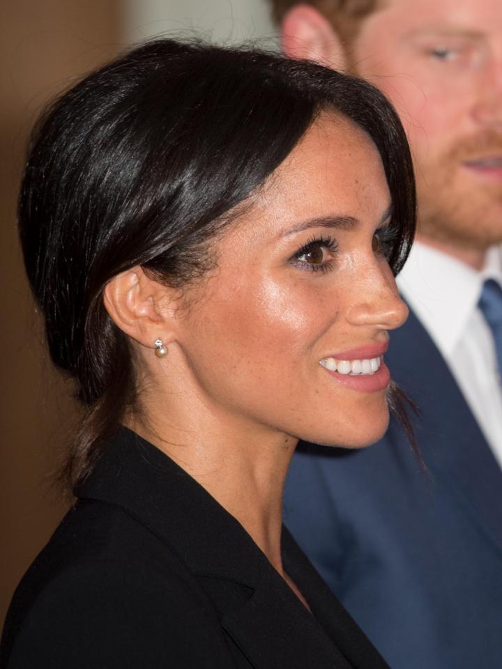  Meghan completed her outfit with a signature low bun and elegant pearl earrings