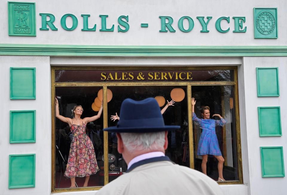  A visitor views models posing in the window of a replica Rolls-Royce showroom