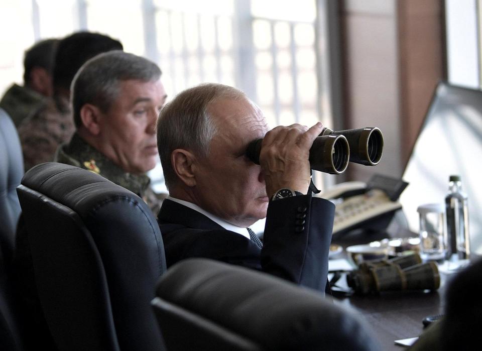  Russian President Vladimir Putin uses a pair of binoculars as he watches his troops in action