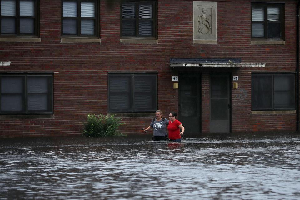  Residents wade through waist-high floodwaters in the deluged town of Bern