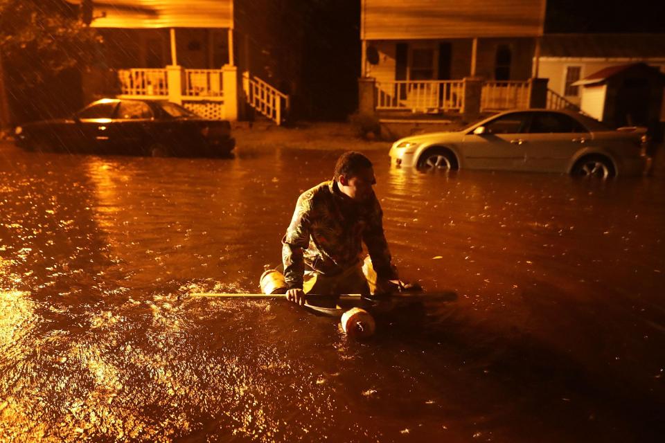  Resident Michael Nelson floats in a boat made from a metal tub and fishing floats after the Neuse River went over its banks and flooded his street