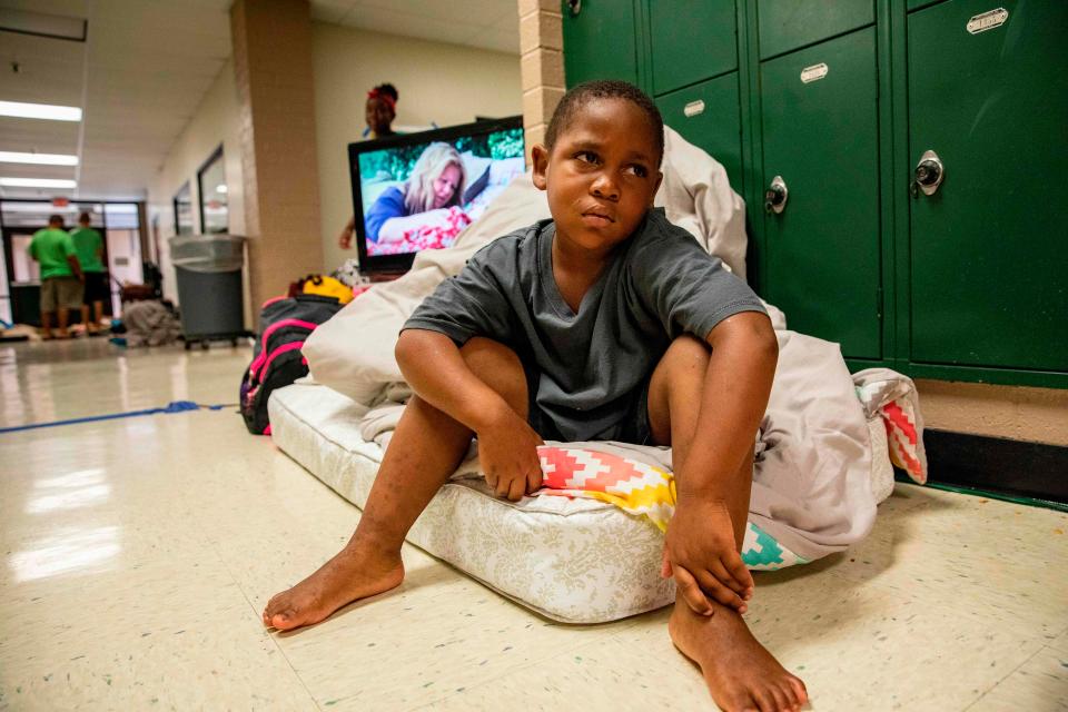  A child sits on a mattress at an evacuation shelter at Conway High School, South Carolina