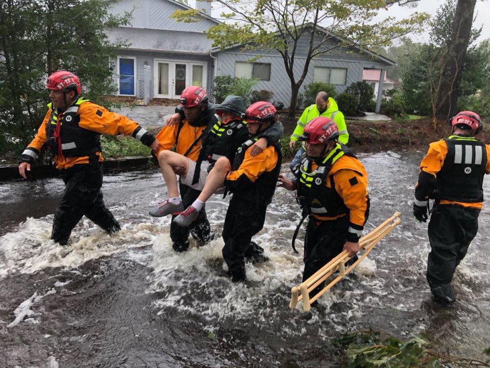  Search and rescue workers rescue a man from the devastating  flooding