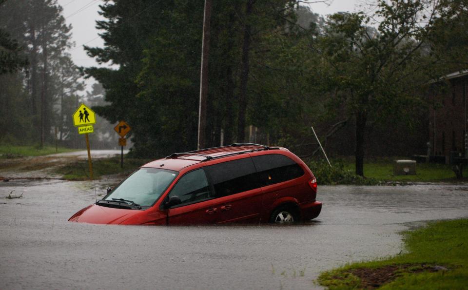  An abandoned mini van sits on a flooded road near New Bern, NC