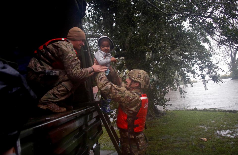  Rescue team members Sgt. Matt Locke, left, and Sgt. Nick Muhar, right, from the North Carolina National Guard 1/120th battalion, evacuates a family