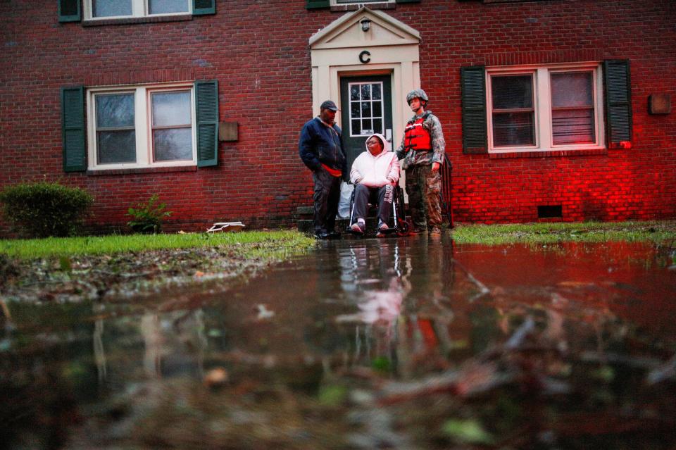  A woman in a wheelchair and attached to a respiratory system is rescued by members of the U.S. Army during the Hurricane in the town of New Bern, North Carolina