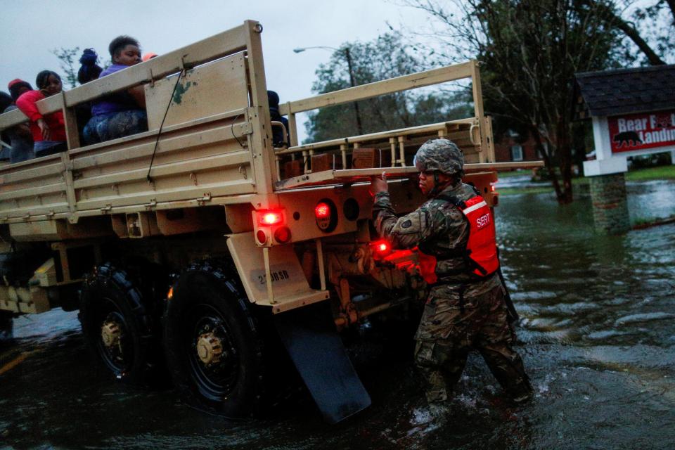  People are rescued by a member of the U.S. Army after floodwaters crept up