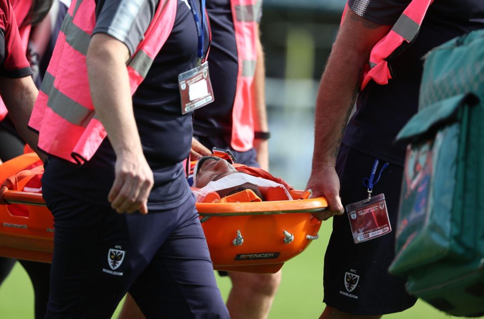  The 21-year-old defender is stretchered off in a neck brace