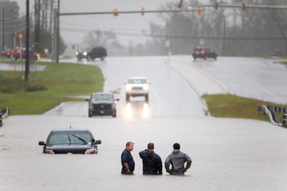  Bystanders help a stranded motorist after floodwaters from Hurricane Florence flooded his car along Route 17 near Holly Ridge, North Carolina