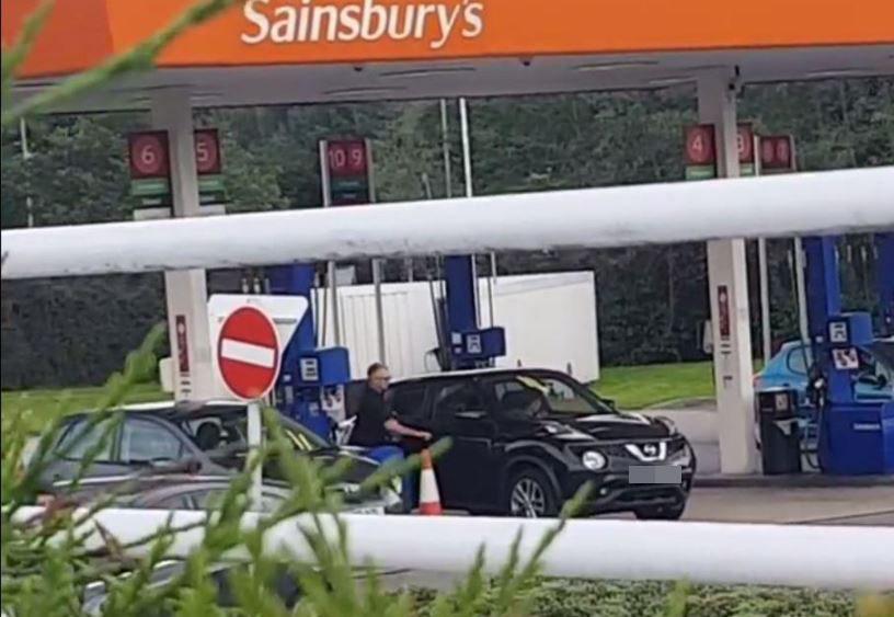  Motorist gets back in his car after megaphone voice tells him pump five is out of order