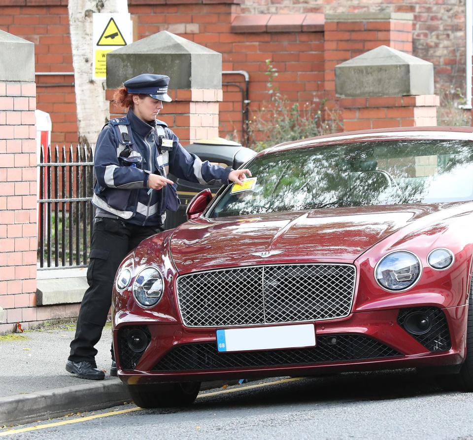  A traffic warden places a parking ticket on Matteo Darmian's Bentley on Monday