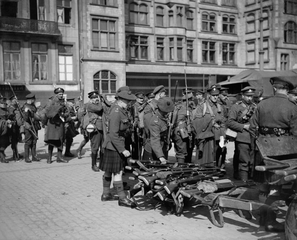  British men handing in their rifles before boarding the Rhine steamer at Cologne on their way back home to England