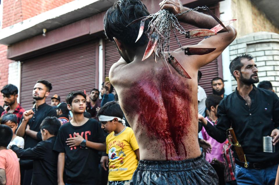 A Kashmiri Shiite Muslim mourner flagellates himself during a religious procession held on the seventh day of Ashura