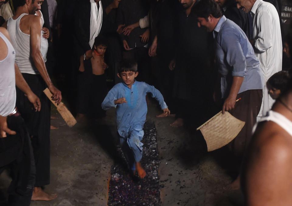 Boys are literately  hauled over the hot coals as they learn to take part from an early age