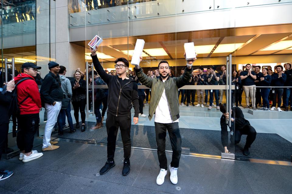  Sydney student Teddy Lee, right, and Mazen Kourouche, left, hold up their new iPhones after being the first customers in line for new products at the Apple Store in Sydney